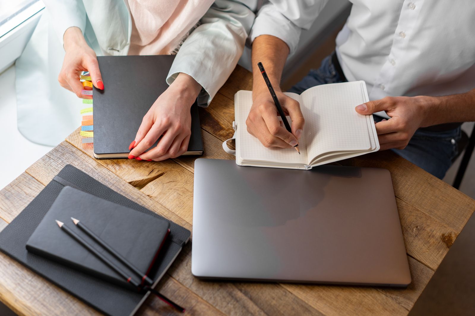 Professionals developing ideas together around a notebook